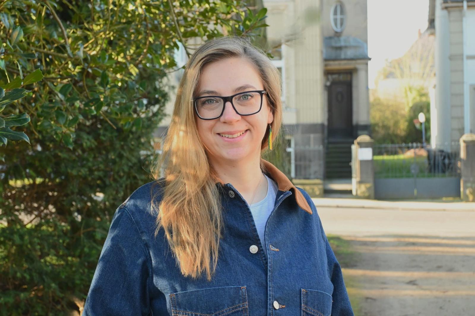 Frau mit langen blonden Haaren und Brille