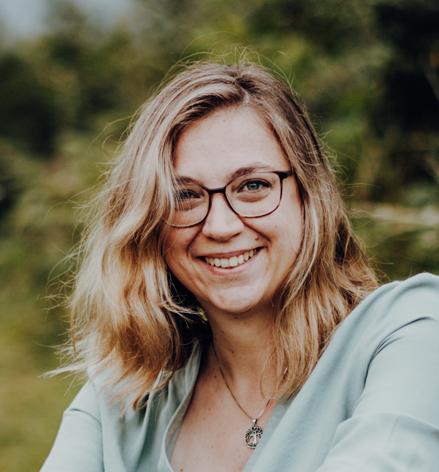 Frau mit halblangen blonden Haaren und Brille